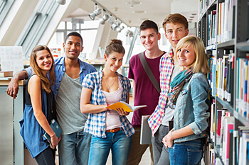 Duales Studium Erfahrungsberichte Gruppe von Studierenden neben Bücherregal