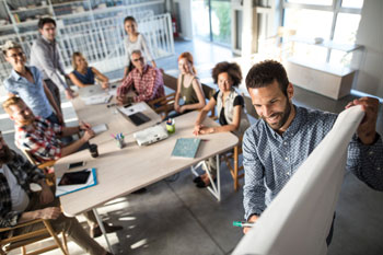 Eventmanager planen gemeinsam am Whiteboard eine Veranstaltung