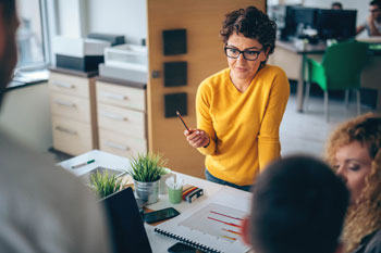 Eventmanager stehen an einem Tisch und planen das nächste große Event